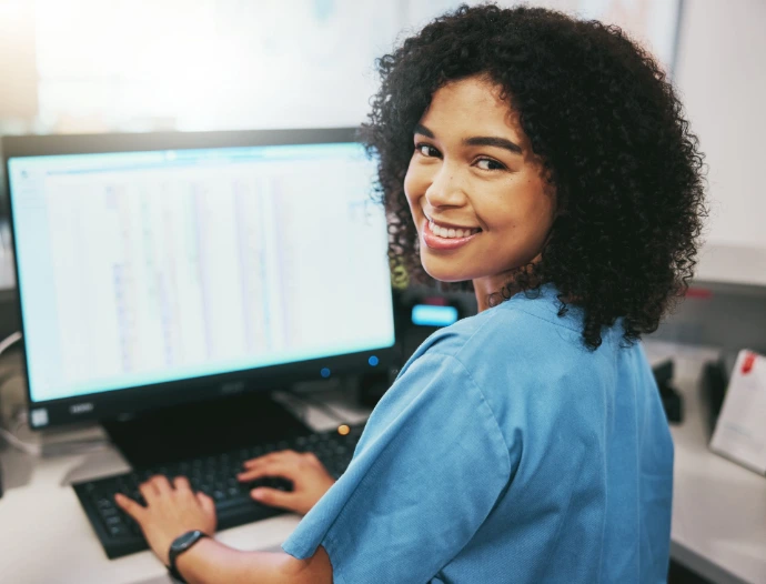 Young woman typing and smiling in camera