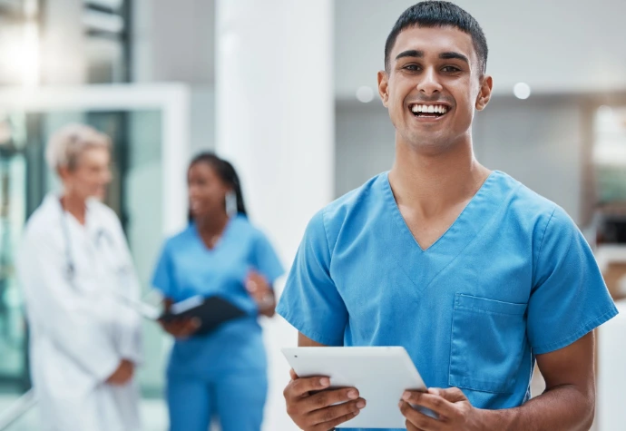 Smiling nurse holding a tablet in a modern hospital environment.