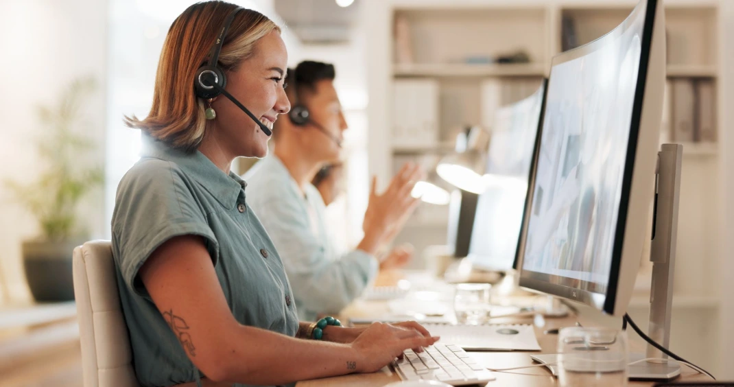 Customer support agent wearing a headset while assisting callers in a modern call center